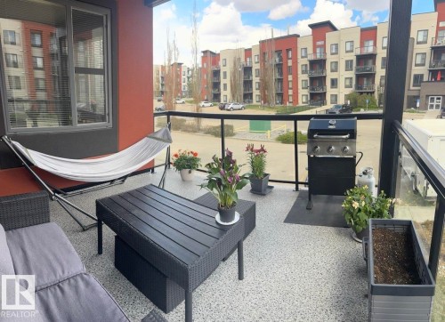 Spacious balcony featuring a composite deck with speckled finish, glass and metal railings, and ample room for outdoor entertaining - 228 308 Ambleside Link Sw, Edmonton, AB - Outdoor With Balcony
