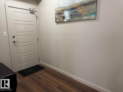 Solid core entry door with four horizontal panels and brushed nickel hardware - 228 308 Ambleside Link Sw, Edmonton, AB - Indoor Photo Showing Other Room