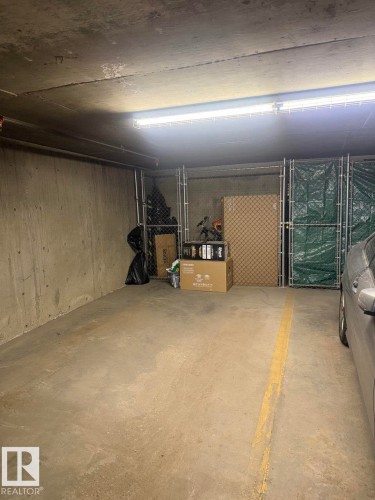 Dedicated parking stall featuring a concrete floor, concrete wall, and overhead fluorescent lighting - 228 308 Ambleside Link Sw, Edmonton, AB - Indoor Photo Showing Garage