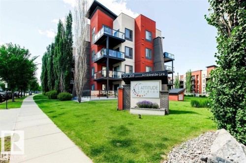 Modern multi-story building featuring red and cream exterior siding with black trim accents - 228 308 Ambleside Link Sw, Edmonton, AB - Outdoor With Balcony