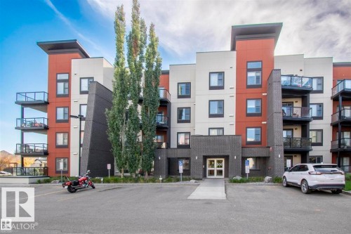 Contemporary multi-story building featuring a facade of white, brick-patterned, and terracotta-colored panels - 228 308 Ambleside Link Sw, Edmonton, AB - Outdoor With Balcony With Facade