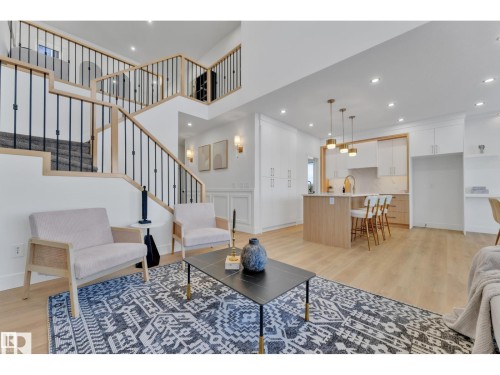 Spacious open-concept living area featuring light wood-finish flooring - 1129 Starling Drive, Edmonton, AB 