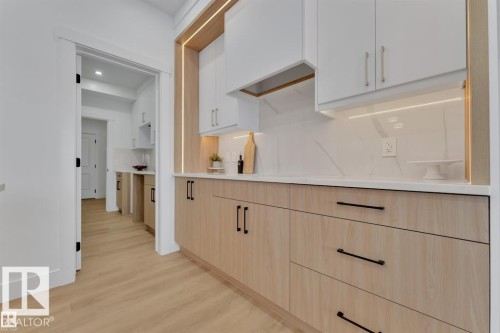 Modern kitchen featuring two-tone cabinetry with light wood-finish lower cabinets and white upper cabinets - 1129 Starling Drive, Edmonton, AB 