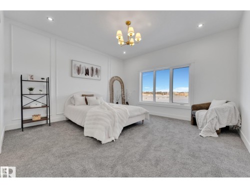 Spacious room featuring broadloom carpet, large windows, recessed lighting, and wall paneling details - 1129 Starling Drive, Edmonton, AB 