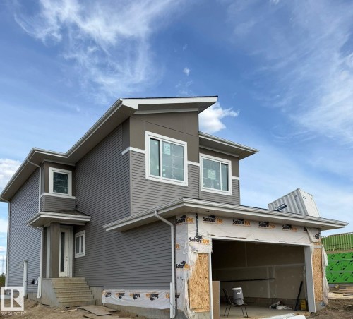 Modern two-story residence with a gray horizontal siding facade and white trim accents - 1129 Starling Drive, Edmonton, AB 