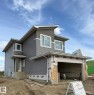 Modern two-story residence with a gray horizontal siding facade and white trim accents - 1129 Starling Drive, Edmonton, AB 
