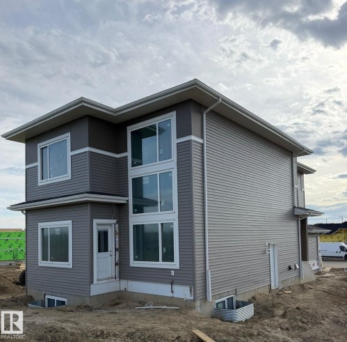 Contemporary exterior featuring multi-toned horizontal siding, expansive multi-pane windows, and white trim accents - 1129 Starling Drive, Edmonton, AB 