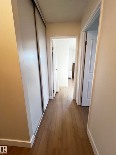 Hallway featuring wood-finish flooring, white baseboards, and neutral wall paint - 807 10011 116 Street, Edmonton, AB - Indoor Photo Showing Other Room