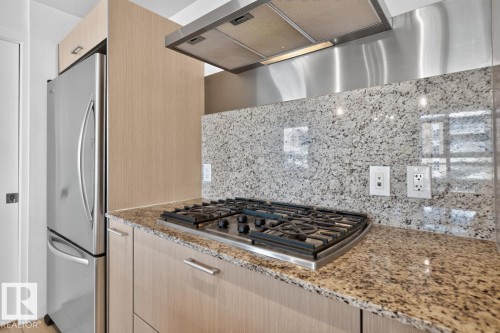 Kitchen featuring a stainless steel refrigerator, four-burner gas cooktop, and a matching stainless steel range hood - #407 2504 109 St Nw, Edmonton, AB - Indoor Photo Showing Kitchen With Upgraded Kitchen