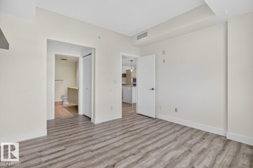 Spacious room featuring wood-finish flooring, white baseboards, and neutral wall tones - #407 2504 109 St Nw, Edmonton, AB - Indoor Photo Showing Other Room