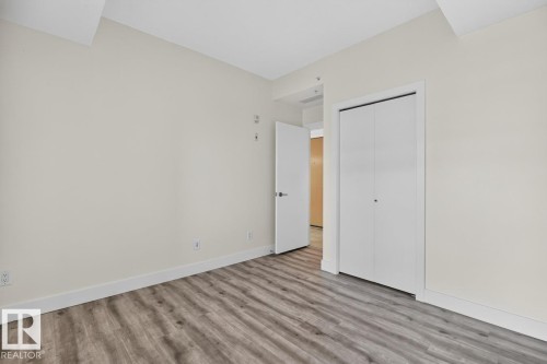 Interior room with light neutral wall paint and wood-finish flooring - #407 2504 109 St Nw, Edmonton, AB - Indoor Photo Showing Other Room