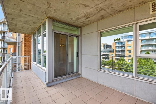 Private balcony featuring tiled flooring and a glass railing, providing access to the interior via a sliding glass door - #407 2504 109 St Nw, Edmonton, AB - Outdoor With Balcony With Exterior