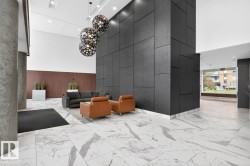 Spacious lobby featuring polished marble-finish flooring and a striking dark paneled accent wall - 