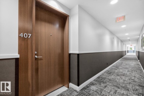 Long hallway with recessed lighting and a patterned carpet - #407 2504 109 St Nw, Edmonton, AB - Indoor Photo Showing Other Room