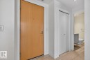 Entryway featuring a light wood-finish door, light-colored tile flooring, flush ceiling lighting, and a white bi-fold closet door - #407 2504 109 St Nw, Edmonton, AB  - Indoor Photo Showing Other Room 
