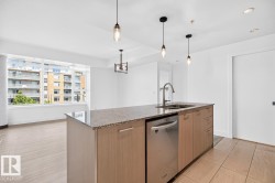 Kitchen island with granite countertop, integrated stainless steel sink, and stainless steel dishwasher - 