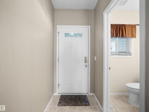 Entryway featuring a white paneled door with integrated glass lites and a neutral tile floor - 16121 131A Street, Edmonton, AB - Indoor Photo Showing Other Room