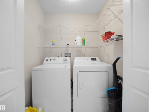 Dedicated laundry area featuring a washer and dryer, complemented by overhead wire shelving for storage - 16121 131A Street, Edmonton, AB - Indoor Photo Showing Laundry Room