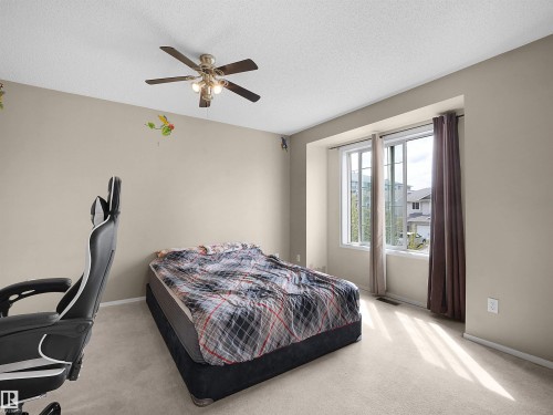 Wall-to-wall carpeting, ceiling fan with integrated lighting, and a large window with white trim - 16121 131A Street, Edmonton, AB - Indoor Photo Showing Bedroom