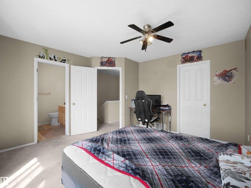 Carpeted room featuring a ceiling fan with integrated lighting, neutral wall tones, and white interior doors - 16121 131A Street, Edmonton, AB - Indoor Photo Showing Bedroom