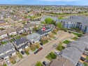 Residential neighborhood with a prominent lake, a large multi-story building, and a distant city skyline - 16121 131A Street, Edmonton, AB  - Outdoor With Body Of Water With View 