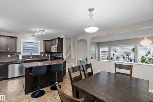 Kitchen with dark wood-finish cabinetry, stainless steel appliances, and a tiled backsplash - 2007 74 Street, Edmonton, AB - Indoor