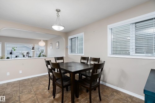 Dining area featuring tile flooring, neutral wall tones, and white window blinds - 2007 74 Street, Edmonton, AB - Indoor Photo Showing Dining Room