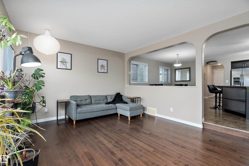 Rich wood-finish flooring extending into the living area - 2007 74 Street, Edmonton, AB - Indoor Photo Showing Other Room