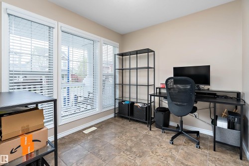 Bright interior space featuring three large windows with white blinds, tile flooring, and neutral wall tones - 2007 74 Street, Edmonton, AB - Indoor Photo Showing Office