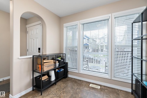 Office featuring an arched opening, a white paneled door, and three windows with white blinds - 2007 74 Street, Edmonton, AB - Indoor Photo Showing Other Room