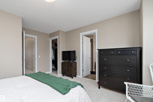 Neutral-toned bedroom featuring plush carpet flooring, white trim, and a ceiling-mounted light fixture - 2007 74 Street, Edmonton, AB - Indoor Photo Showing Bedroom