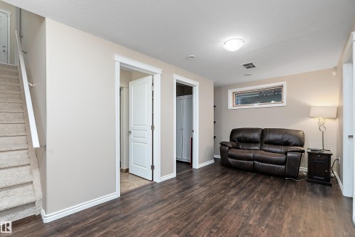 Spacious lower-level area featuring wood-finish flooring, a neutral color palette, recessed lighting, and a horizontal window - 2007 74 Street, Edmonton, AB - Indoor