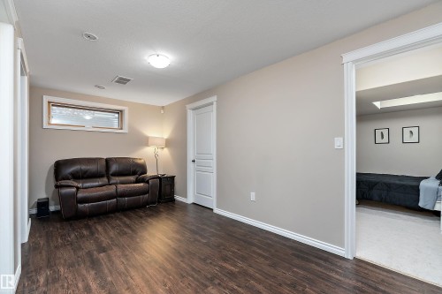 Spacious living area featuring wood-finish flooring, neutral wall tones, and recessed lighting - 2007 74 Street, Edmonton, AB - Indoor Photo Showing Living Room