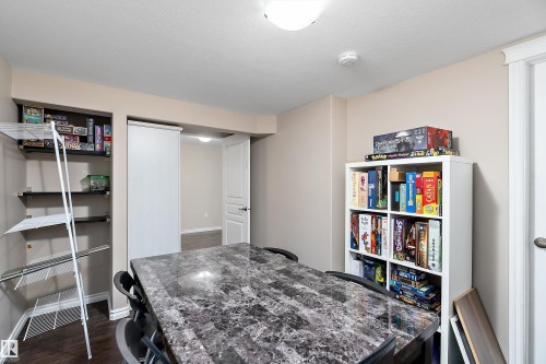 Bedroom converted to games room featuring dark wood-finish flooring and neutral wall tones - 2007 74 Street, Edmonton, AB - Indoor