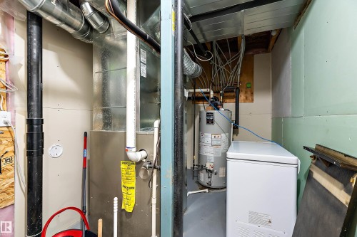 Utility area featuring a water heater, furnace, and exposed ductwork - 2007 74 Street, Edmonton, AB - Indoor Photo Showing Basement