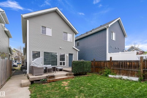 Rear exterior featuring light grey horizontal siding, a private wooden deck, and a fenced backyard with natural grass - 2007 74 Street, Edmonton, AB - Outdoor With Deck Patio Veranda With Exterior