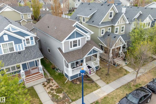 Two-story residence featuring a shingled roof and light gray siding with blue accent gables - 2007 74 Street, Edmonton, AB - Outdoor With Facade