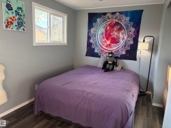 Room featuring wood-finish flooring, light grey painted walls, and white baseboards - 