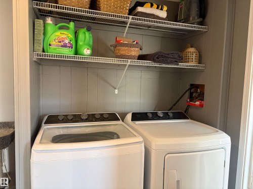 Laundry closet featuring a washer and dryer, painted paneling, and wire shelving - 4108 49 Avenue, Bonnyville Town, AB - Indoor Photo Showing Laundry Room