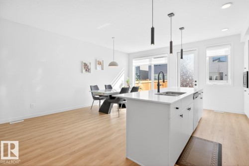 Open-concept kitchen and dining area with light wood-finish flooring - 17347 100 Street, Edmonton, AB - Indoor Photo Showing Kitchen With Upgraded Kitchen