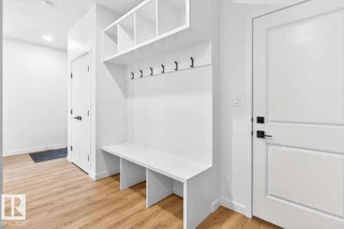 Built-in mudroom bench with cubby storage, coat hooks, and wood-finish flooring - 17347 100 Street, Edmonton, AB - Indoor Photo Showing Other Room