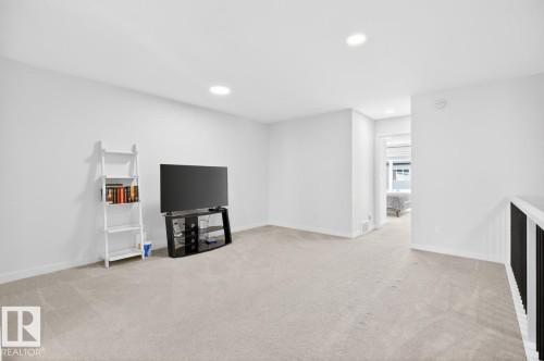 Spacious room featuring light neutral carpeting, recessed ceiling lighting, and crisp white walls - 17347 100 Street, Edmonton, AB - Indoor