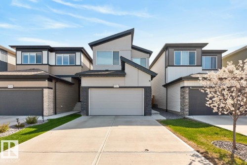 Contemporary exterior featuring a multi-tone facade with dark trim, stone accents, and varied siding - 17347 100 Street, Edmonton, AB - Outdoor