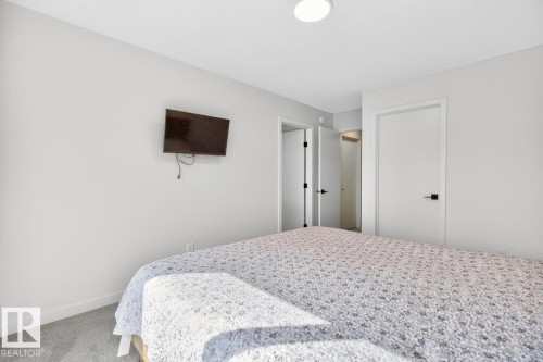 White-painted bedroom featuring light gray carpet, recessed ceiling lighting, and multiple interior doors with matte black hardware - 17347 100 Street, Edmonton, AB - Indoor Photo Showing Bedroom