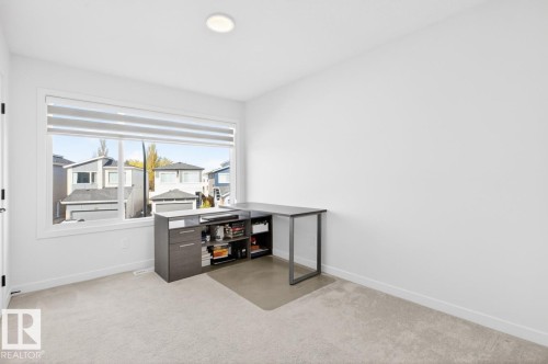 Light-toned carpeting complements the white walls and trim, with a large window providing ample natural illumination - 17347 100 Street, Edmonton, AB - Indoor