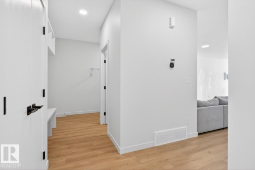 Entryway featuring wood-finish flooring, white walls, recessed ceiling lighting, and a built-in storage bench with shelving - 17347 100 Street, Edmonton, AB - Indoor Photo Showing Other Room