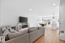 Open-concept living space featuring wood-finish flooring, recessed lighting, and a modern built-in electric fireplace entertainment unit - 17347 100 Street, Edmonton, AB  - Indoor Photo Showing Living Room 