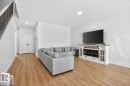 Living space featuring wood-finish flooring, recessed lighting, and a built-in entertainment console with an electric fireplace - 17347 100 Street, Edmonton, AB  - Indoor Photo Showing Living Room With Fireplace 