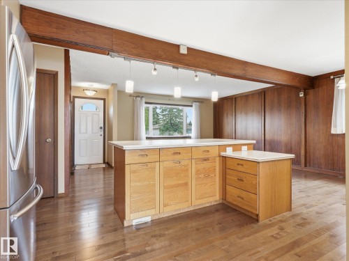 Kitchen island with light wood cabinetry and a light-toned countertop - 13504 116 St Nw, Edmonton, AB - Indoor Photo Showing Kitchen
