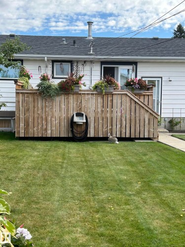 Expansive lawn with a wood privacy deck and staircase - 13504 116 St Nw, Edmonton, AB - Outdoor
